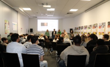 Informationsveranstaltung 2025 im BIZ Aschaffenburg Mehrere Menschen sind von hinten zu sehen. Sie blicken nach vorne zu einer Gruppe der Gastgeber vor einer Präsentation.