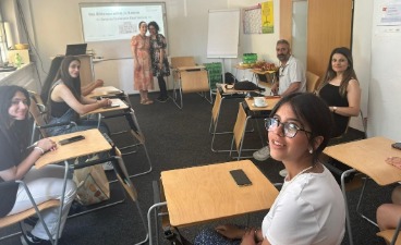 Ein kleiner Schulungsraum mit wenigen Personen an Tischen in einer Runde.