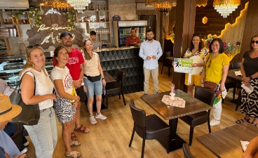 Betriebs-Spaziergang auf der RefugeeWeek Eine Gruppe von Menschen steht in einem Restaurant.